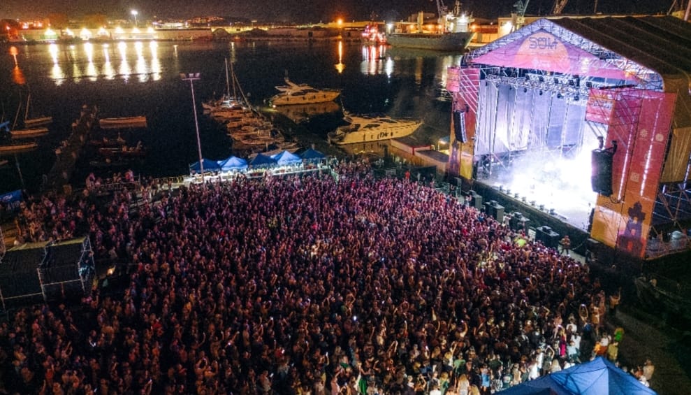 Concierto al aire libre en Castellón, escenario iluminado y público frente al escenario.