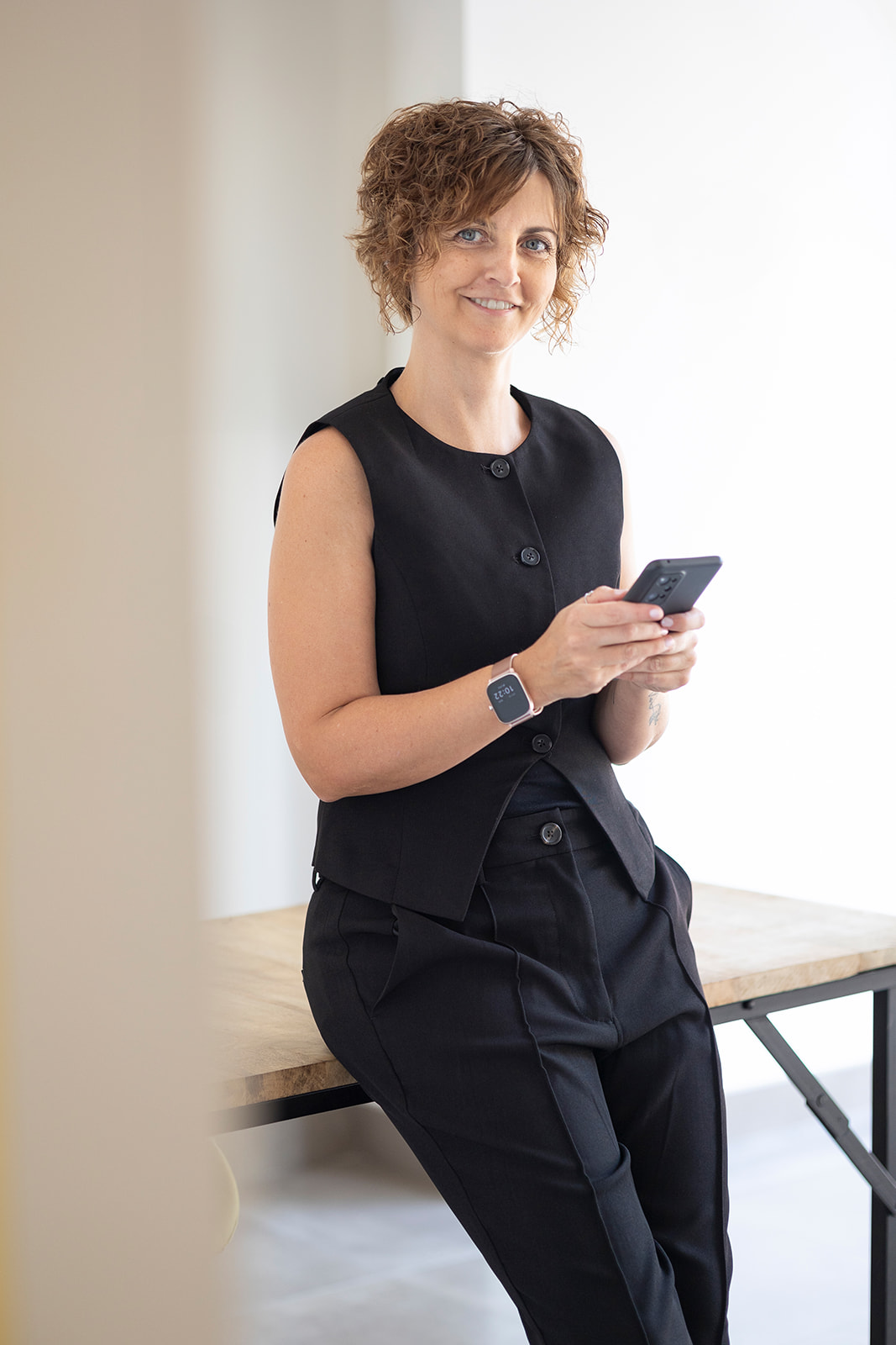 Berta Torres, asistente virtual estratégica, sentada con el móvil en la mano