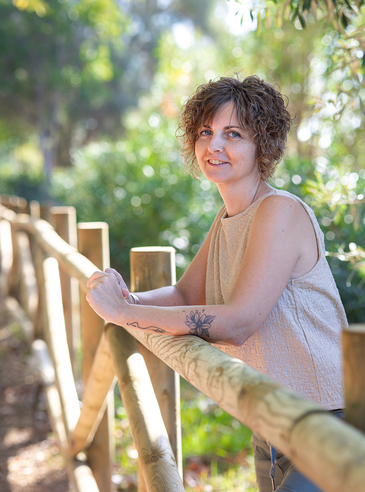 Berta Torres, asistente virtual estratégica, sonriendo al aire libre junto a una valla de madera
